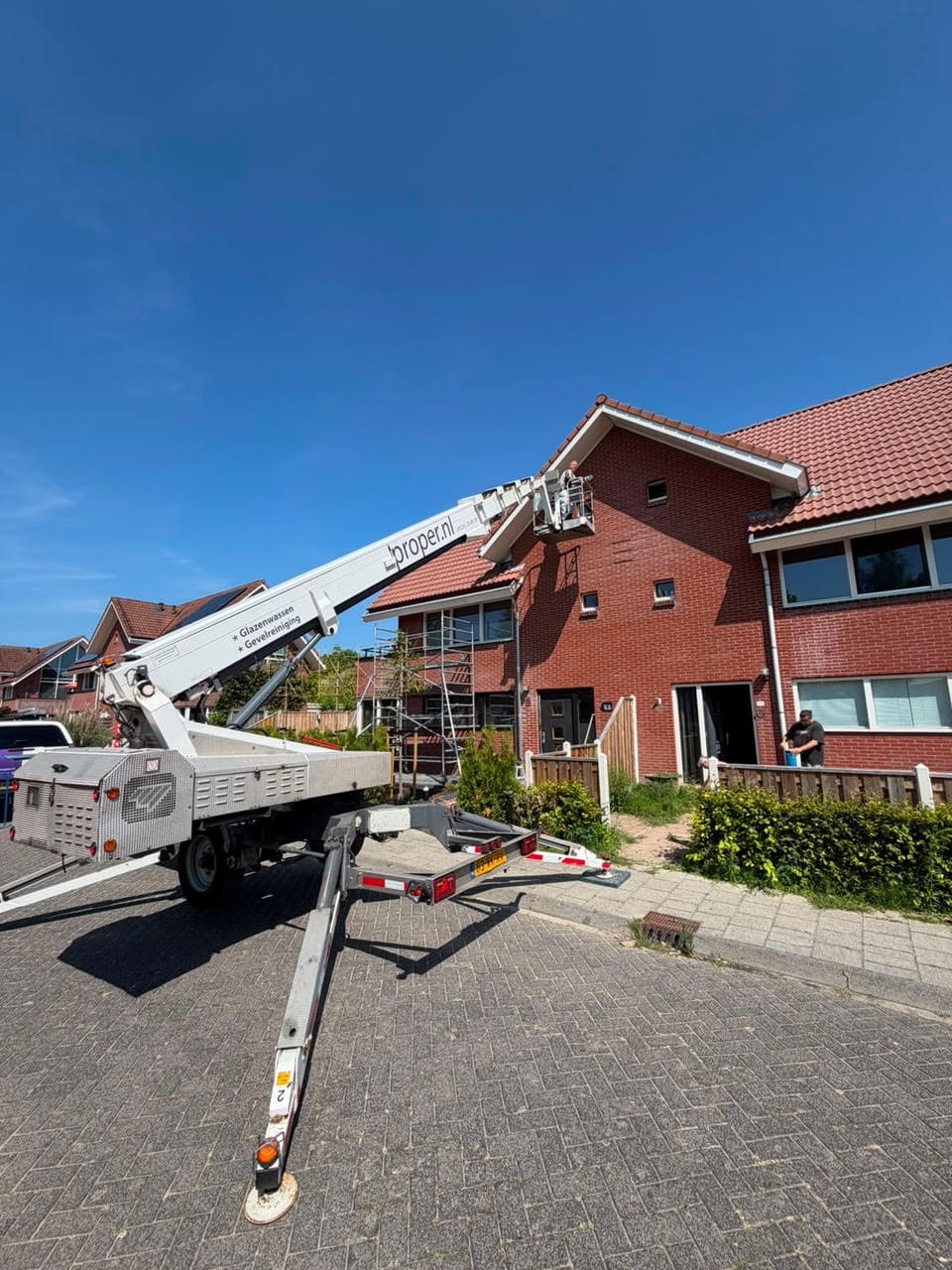 Hoogwerker bij buitenschilderwerk aan woning in Pauwenburg Lelystad