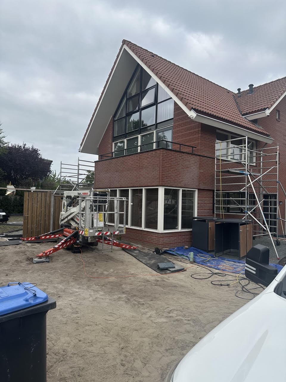 Achtergevel met driehoekige glaspartij en steiger tijdens schilderwerk Lelystad Pauwenburg